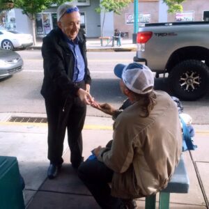 Jeremy Reynalds gives a meal card to a hungry man in Downtown Albuquerque.